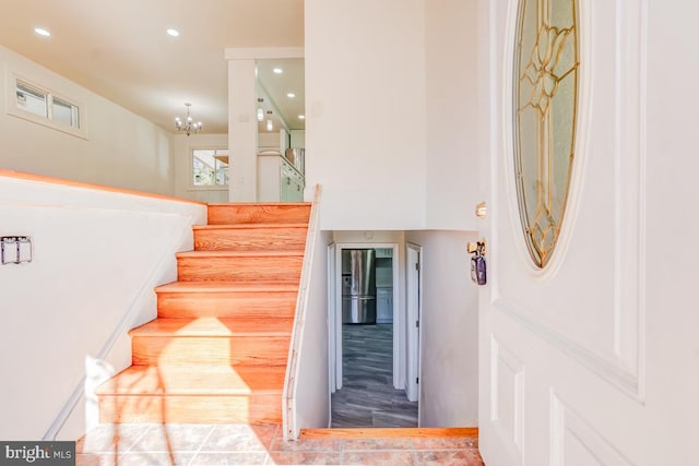 stairs featuring recessed lighting and a notable chandelier