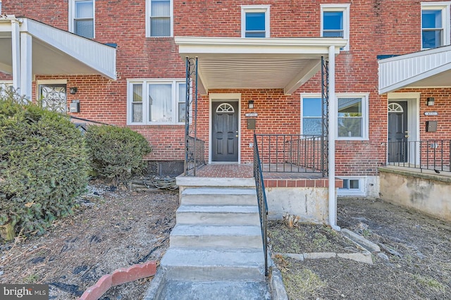 doorway to property with brick siding