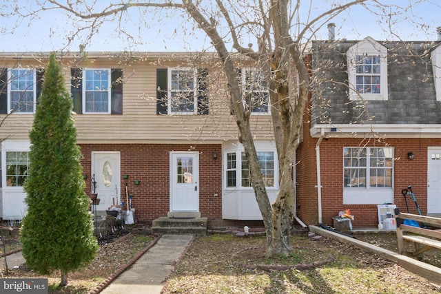 view of property with entry steps and brick siding