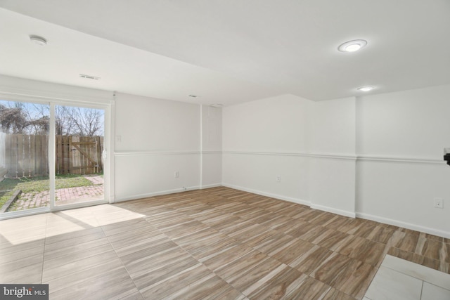 spare room with baseboards and visible vents