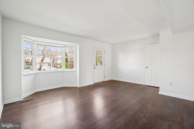 foyer entrance featuring dark wood-style floors, visible vents, and baseboards