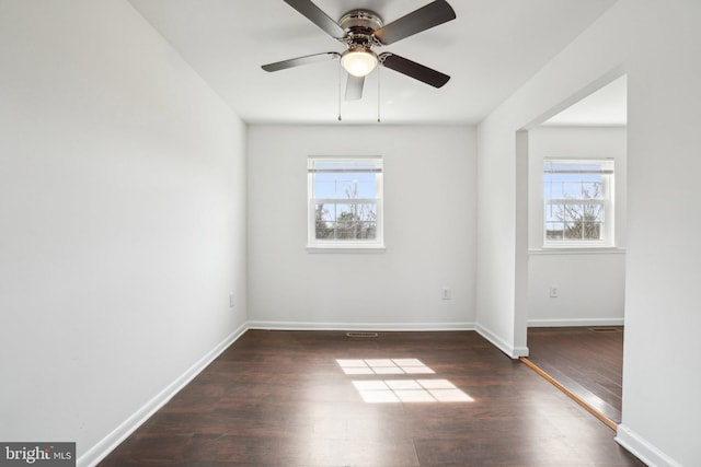 spare room with wood finished floors, baseboards, and ceiling fan