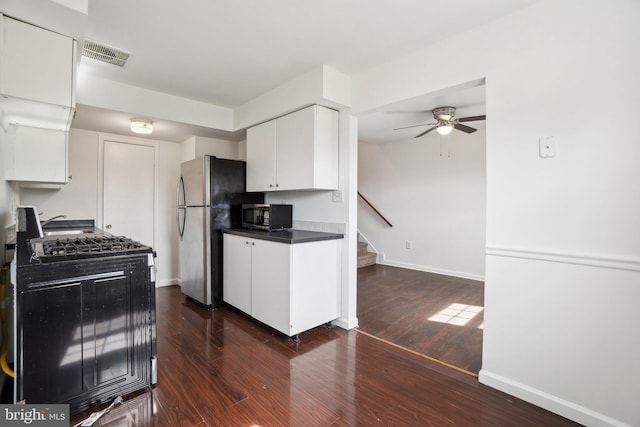 kitchen with stainless steel appliances, dark wood-type flooring, visible vents, and white cabinetry