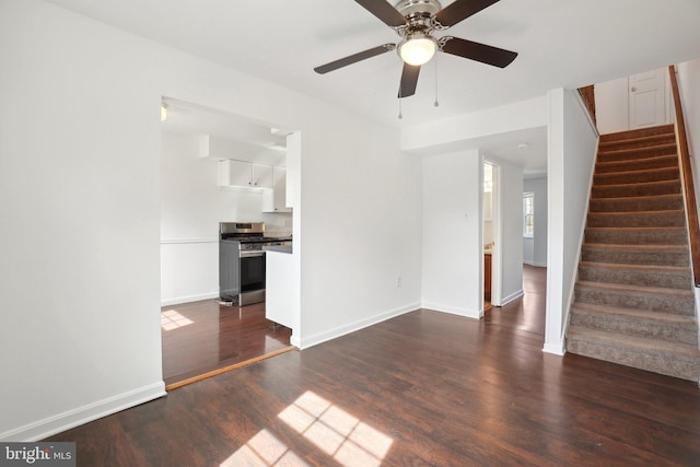 unfurnished living room featuring stairs, baseboards, dark wood-style flooring, and a ceiling fan