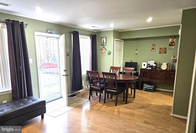 dining area featuring visible vents, crown molding, and light wood finished floors