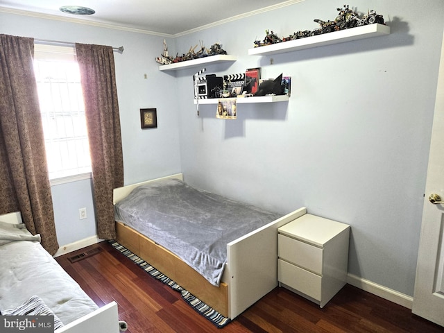 bedroom with visible vents, baseboards, dark wood-type flooring, and ornamental molding