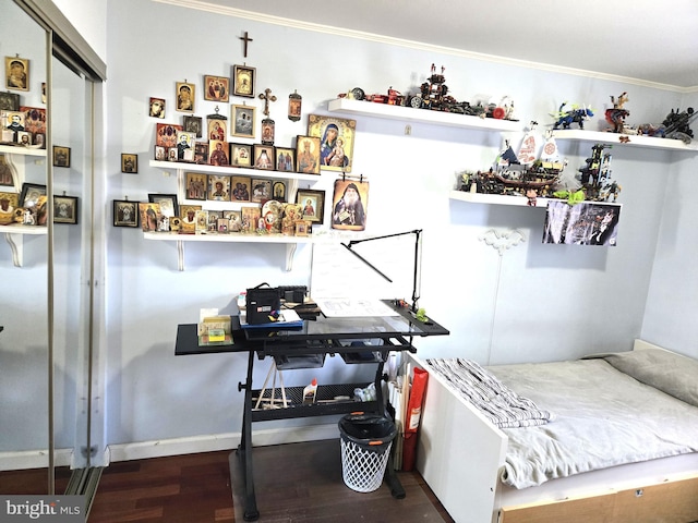 bedroom with ornamental molding and wood finished floors