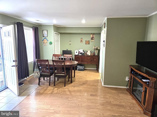 dining area with baseboards, light wood-type flooring, and ornamental molding