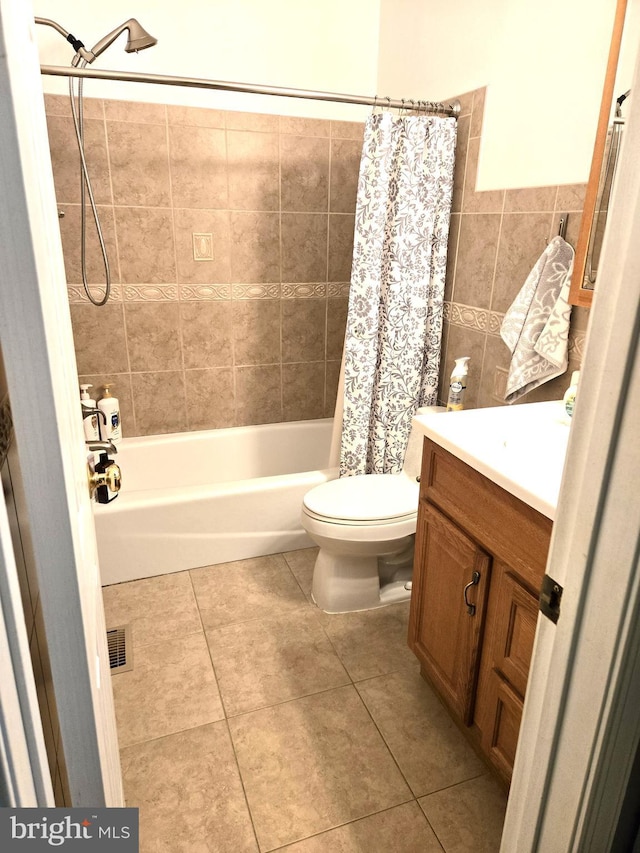 bathroom featuring tile walls, toilet, shower / tub combo with curtain, tile patterned floors, and vanity