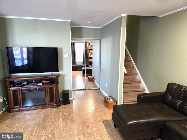 living room with baseboards, wood finished floors, stairs, and ornamental molding