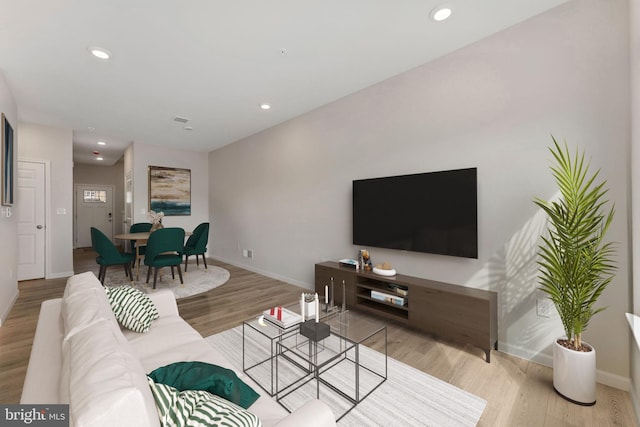 living room featuring recessed lighting, baseboards, and wood finished floors