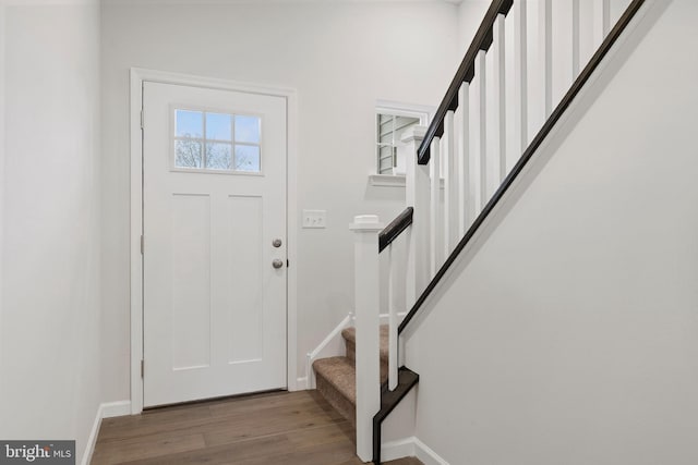 foyer featuring stairs, wood finished floors, and baseboards