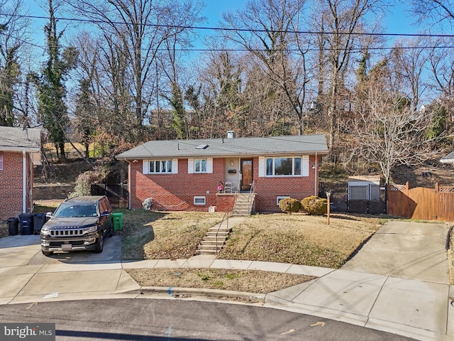 view of front of house featuring brick siding and fence