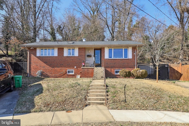 view of front facade featuring a front yard, fence, and brick siding