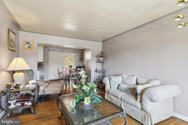 living area with baseboards and wood finished floors