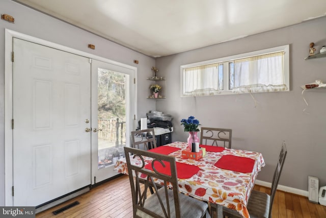 dining area featuring visible vents, baseboards, and hardwood / wood-style flooring