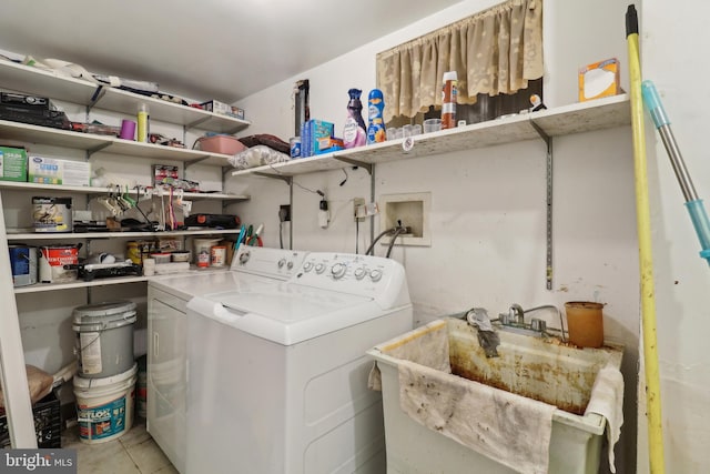 laundry area featuring a sink, washing machine and dryer, laundry area, and tile patterned floors