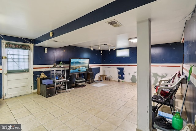 interior space with visible vents, wainscoting, rail lighting, and plenty of natural light