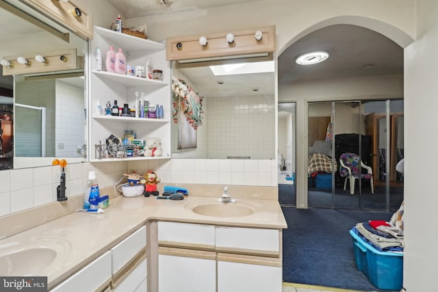 bathroom with tasteful backsplash, double vanity, and a sink