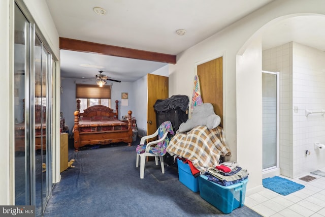 bedroom featuring connected bathroom, beam ceiling, arched walkways, and carpet floors