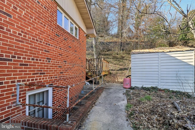 view of side of property with brick siding and an outbuilding