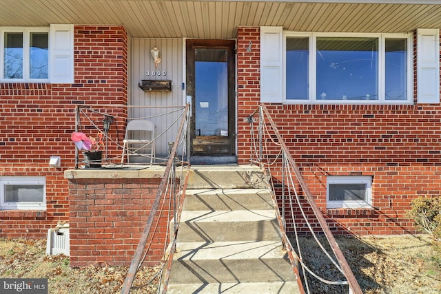 doorway to property with brick siding