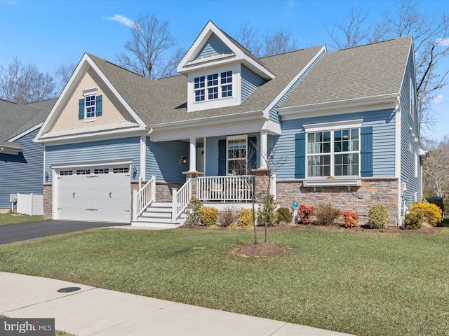 craftsman inspired home with a porch, stone siding, driveway, and a front lawn