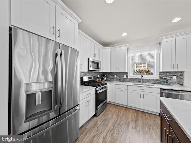 kitchen with a sink, white cabinets, and stainless steel appliances