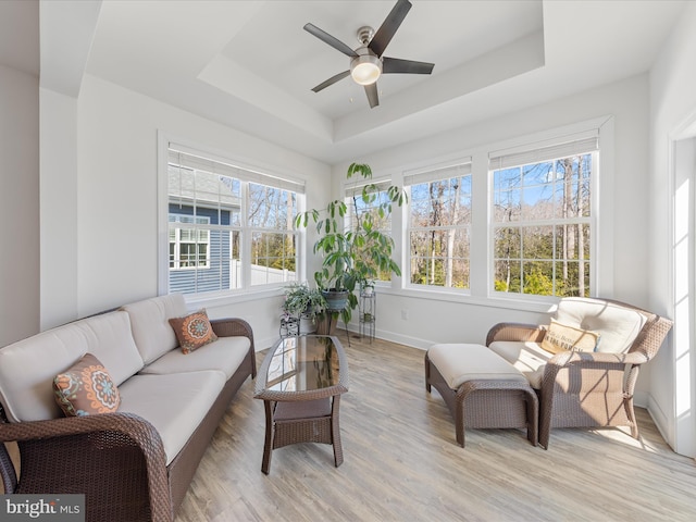 sunroom featuring a tray ceiling and ceiling fan