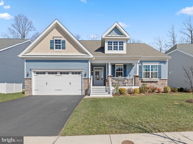 craftsman inspired home with covered porch, a front lawn, stone siding, aphalt driveway, and board and batten siding