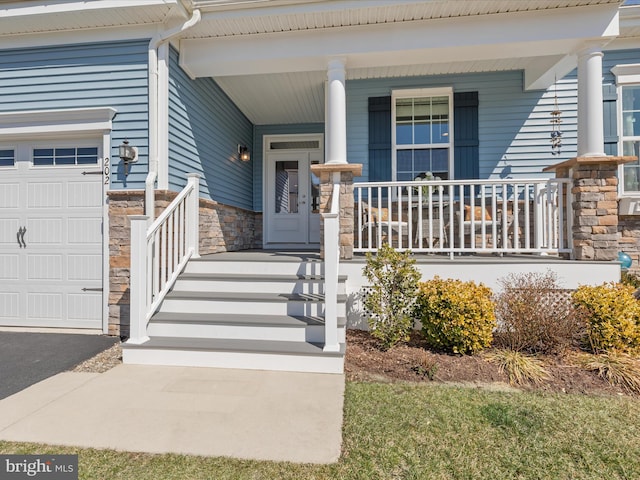 property entrance featuring a porch, a garage, and stone siding