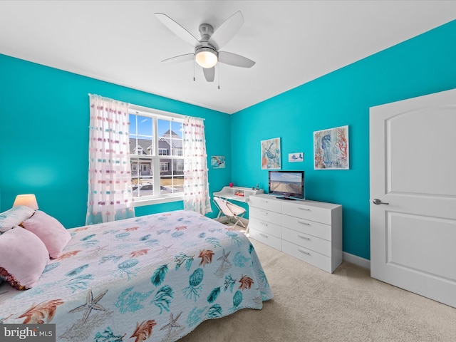 carpeted bedroom featuring baseboards and ceiling fan