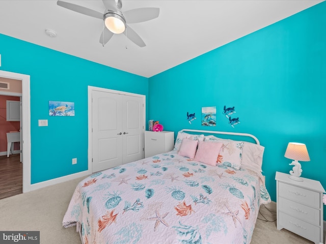 carpeted bedroom featuring a closet, baseboards, visible vents, and ceiling fan