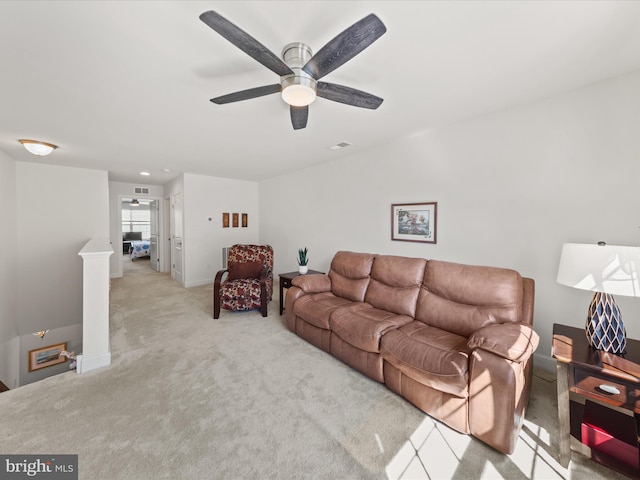 carpeted living room featuring a ceiling fan, visible vents, and baseboards