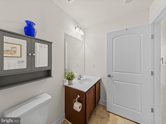 bathroom with baseboards, toilet, and vanity