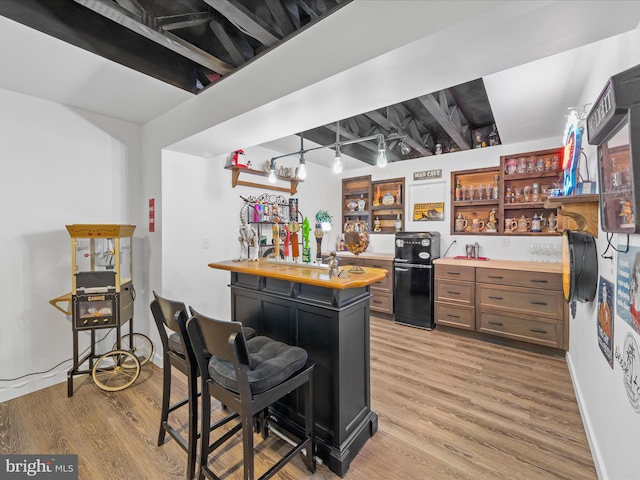 kitchen featuring baseboards, wood counters, light wood-type flooring, fridge, and open shelves