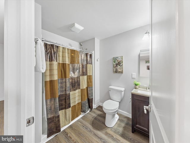 full bath with visible vents, toilet, curtained shower, wood finished floors, and vanity