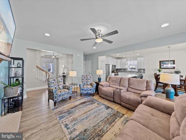 living area featuring stairway, recessed lighting, a ceiling fan, and light wood-style floors