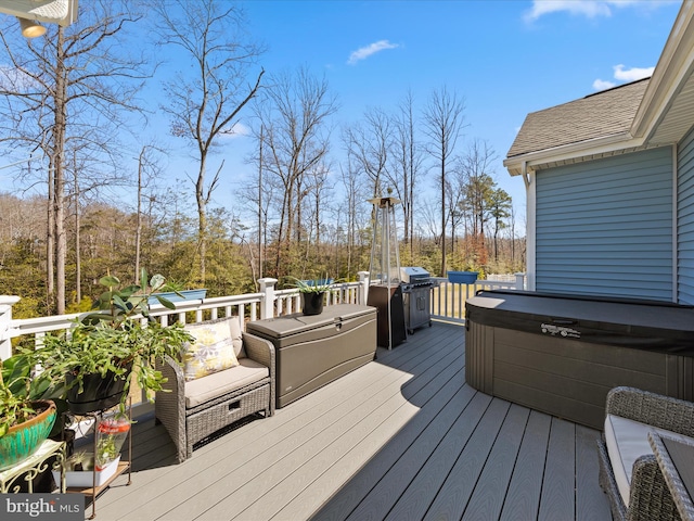 deck with area for grilling and a hot tub