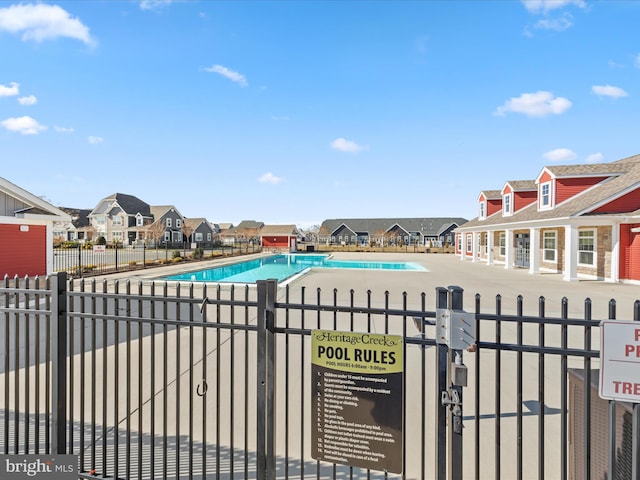 pool with a gate, a residential view, and fence