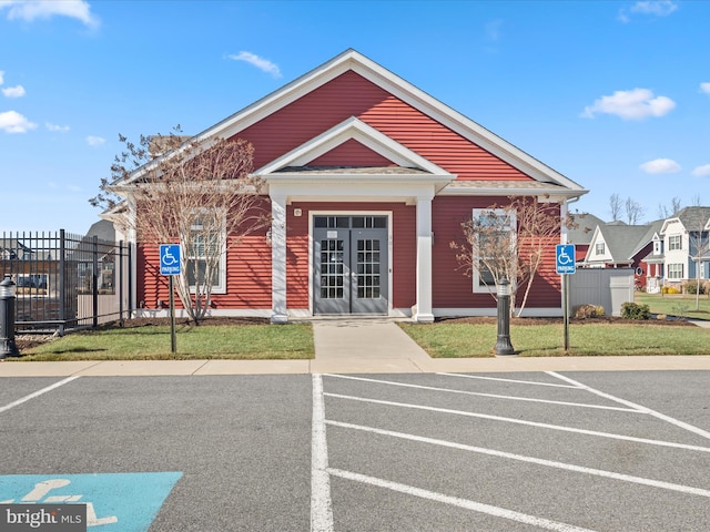 view of building exterior with uncovered parking and fence