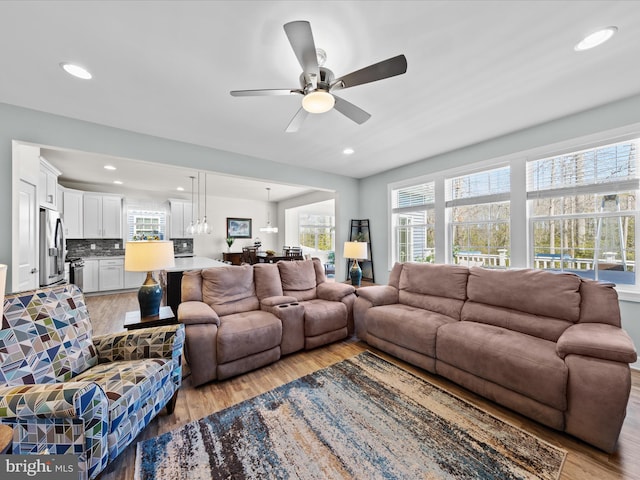 living room with recessed lighting, ceiling fan, and light wood-style floors