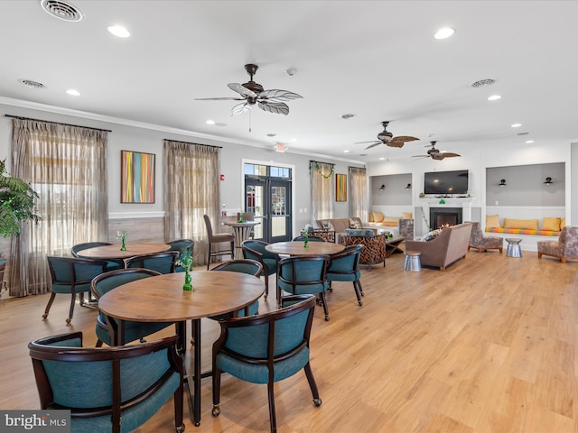 dining room featuring visible vents, light wood-style flooring, and crown molding