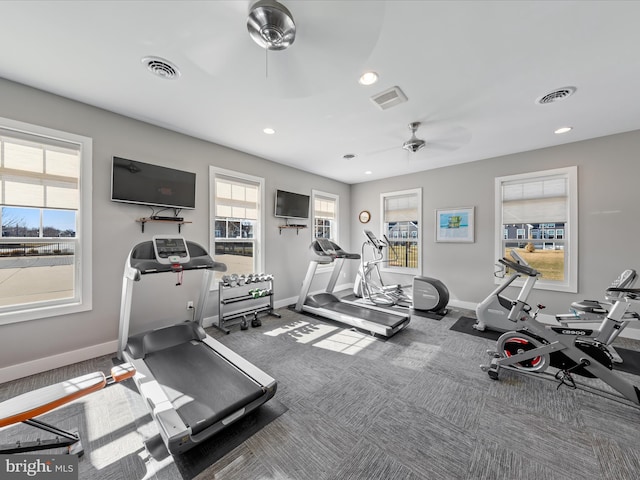 exercise room with visible vents, a ceiling fan, and baseboards