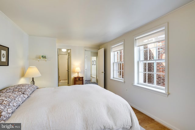 bedroom with baseboards and wood finished floors