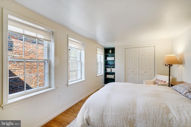 bedroom with a closet, baseboards, and wood finished floors