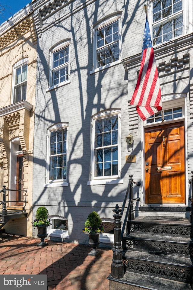 view of exterior entry featuring brick siding