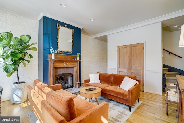 living area with stairway, ornamental molding, and light wood finished floors