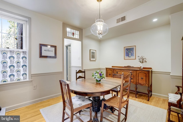 dining room with a notable chandelier, visible vents, light wood-type flooring, and baseboards