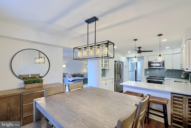 dining area with a ceiling fan, recessed lighting, beverage cooler, and dark wood-style flooring